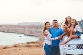 Familie im Mietwagen am Meer