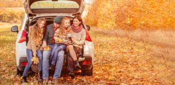 Familie im Mietwagen während des Herbst