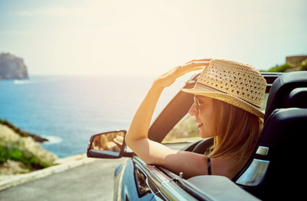 Frau mit Hut im Cabrio